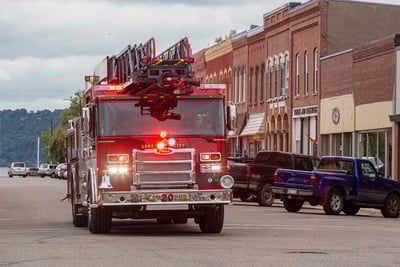 Low intensity emergency response lighting reduces the light output of warning lights in low light situations, like this scenario of a truck driving through a busy downtown area at dusk.