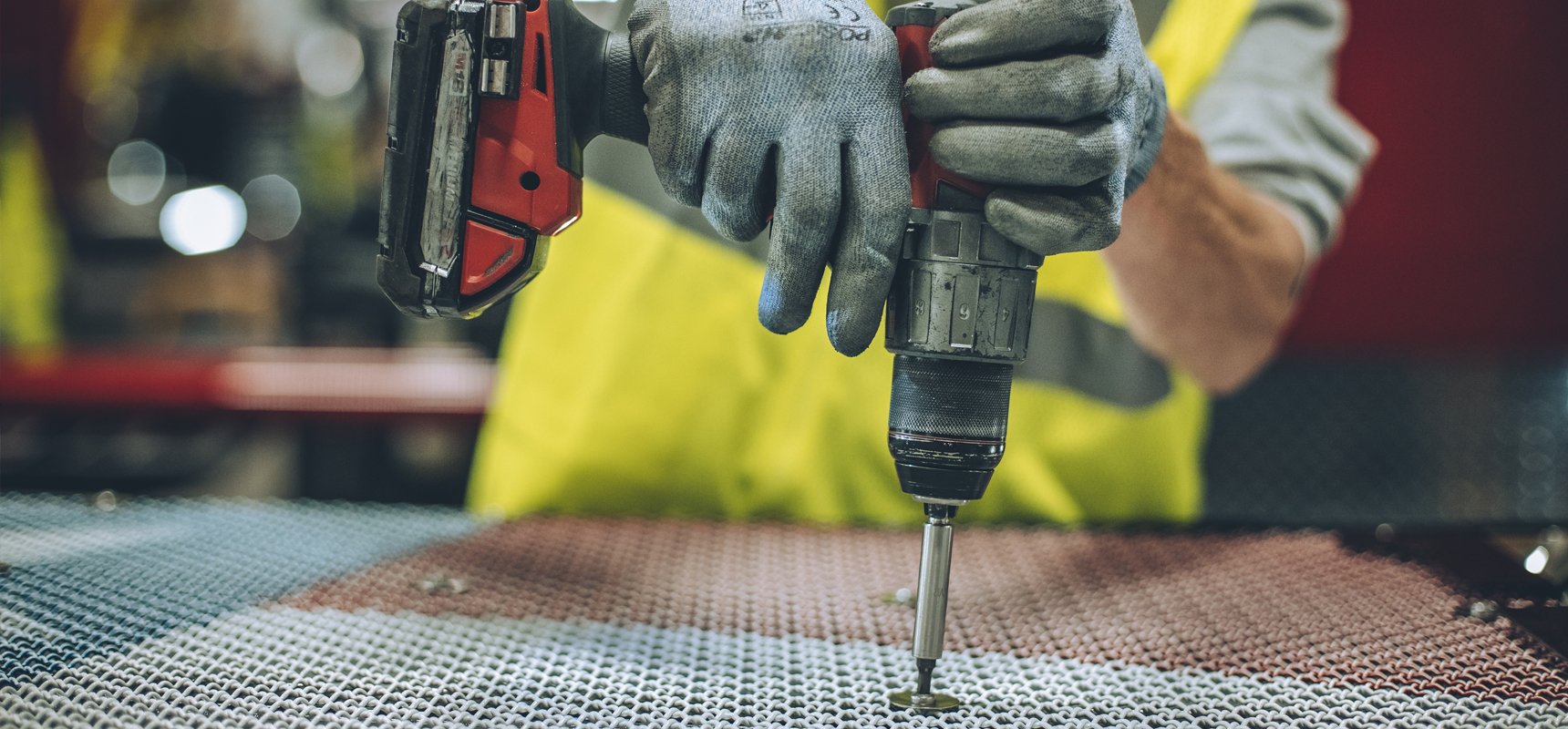 A close up image of a Pierce team member drilling on the manufacturing floor. 