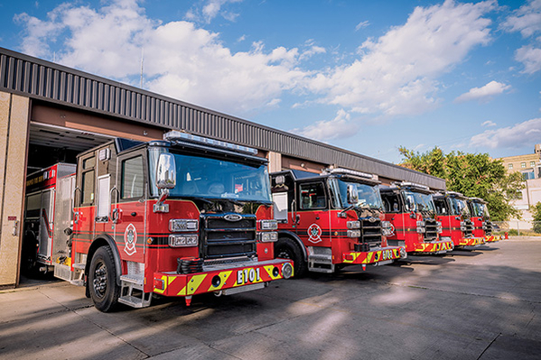 Five pumper fire trucks pulling out of fire station in Winnipeg Canada