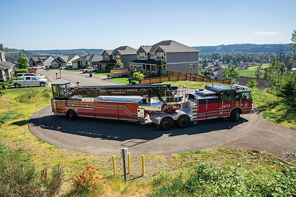 Tractror Drawn Aerial Tiller Fire Truck turning around using tight turning radius in suburb round about