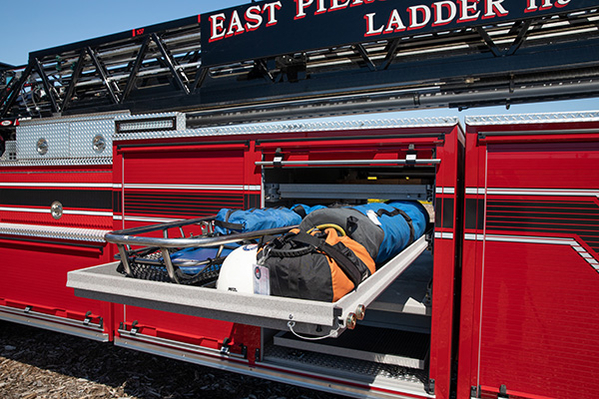 Compartment with firefighting equipment on tiller aerial ladder fire truck