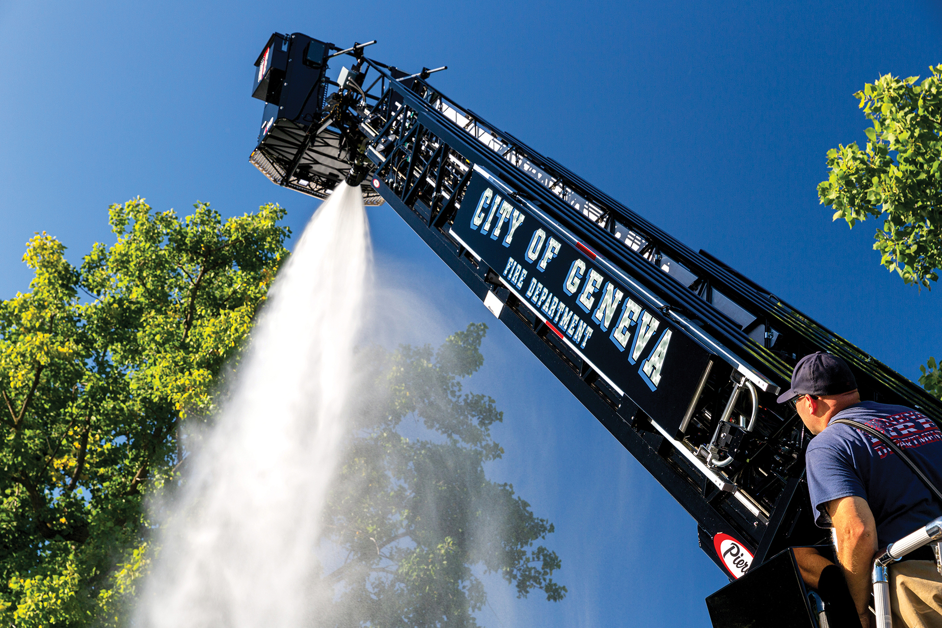 Firefighter operating and spraying water from an Ascendant 110 Aerial Platform Fire Truck