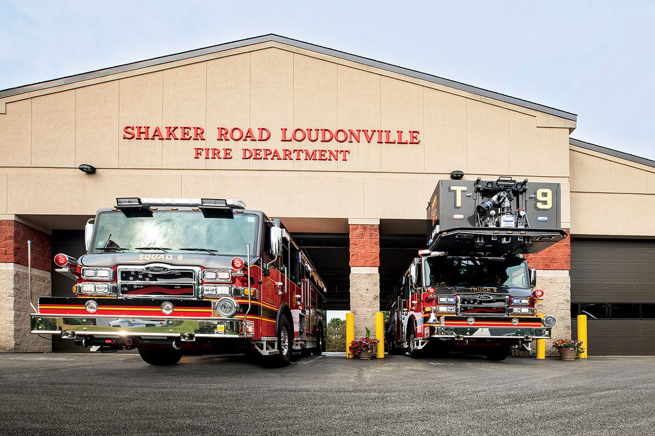 An aerial fire truck and a pumper pulling out of fire station