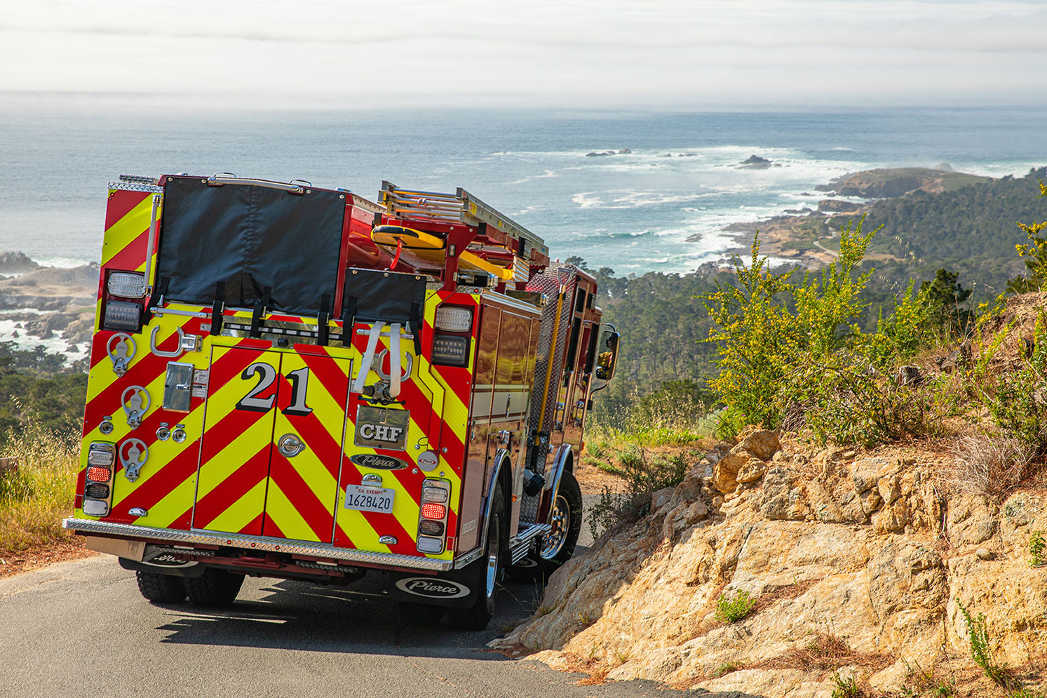Fire engine driving on a downhill slope along shore of Atlantic Ocean