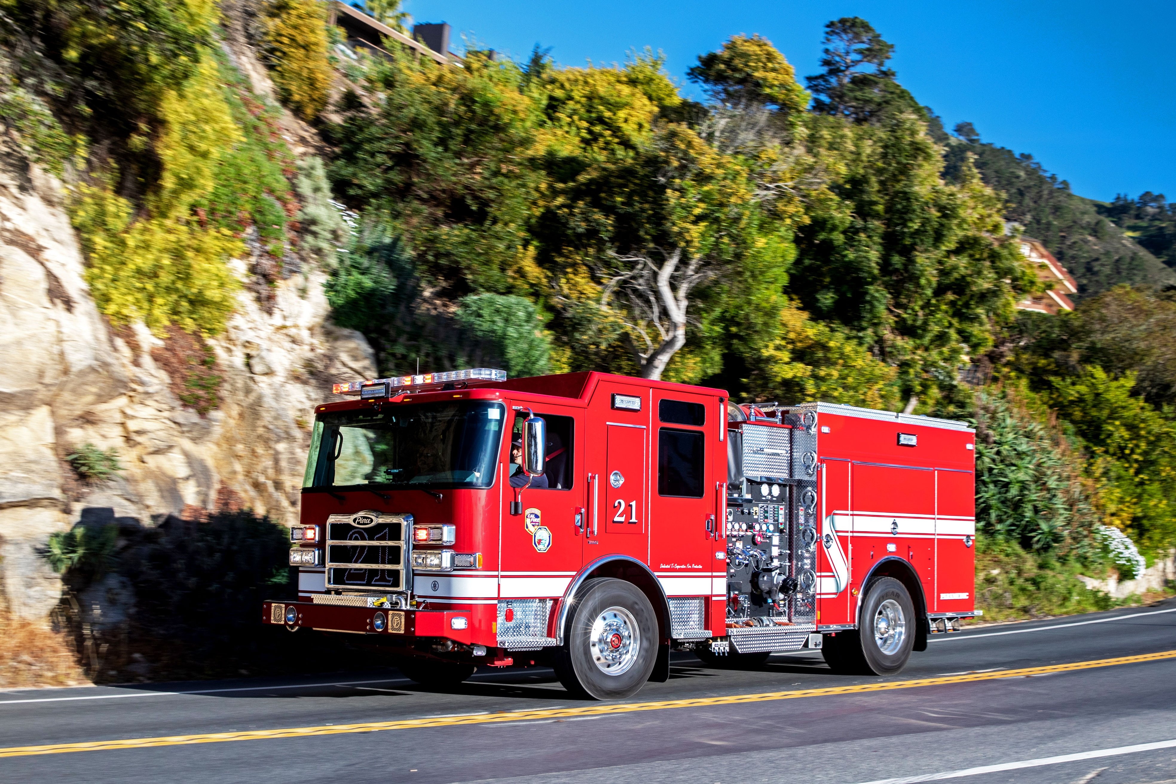 Pumper fire truck driving on road on a sunny day