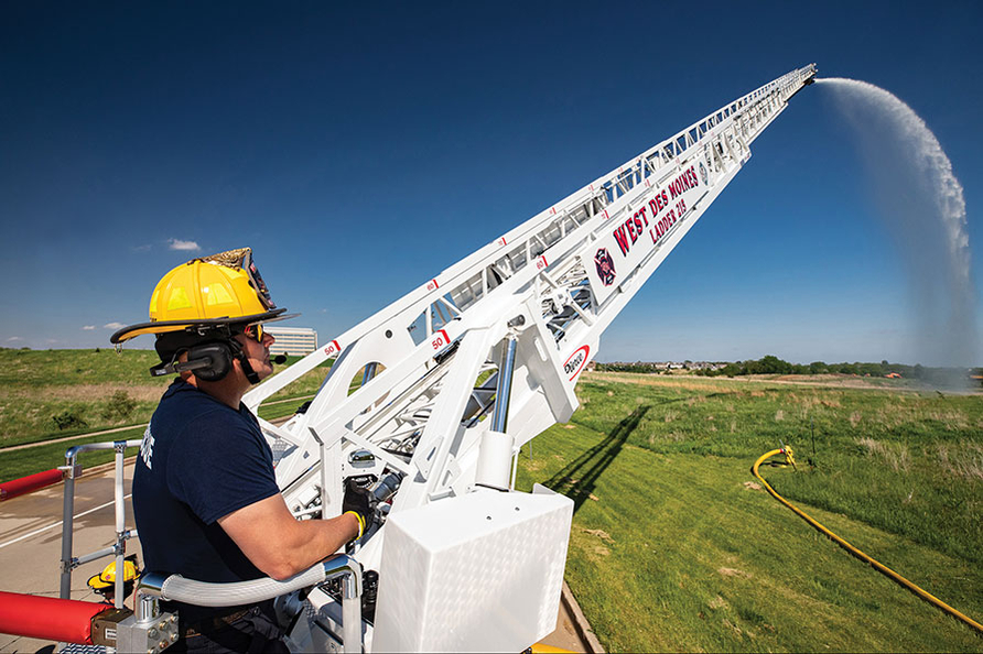 Firefigher flowing water off of Ascendant 107 Heavy-Duty Tiller Tractor Drawn Aerial