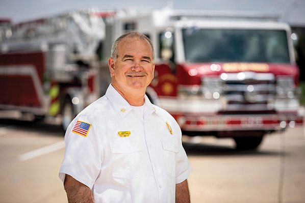 West Des Moines Fire Department Chief in front of their Pierce Tiller Fire Truck