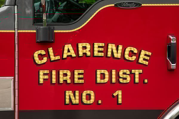 The logo for Clarence Fire District No.1 in gold leaf on the drivers side door of a fire truck.