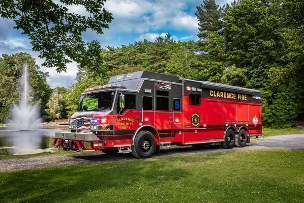 Thumb The front drivers side of a Velocity Combination Walk-in Non-Walk-In fire truck parked next to a pond with a fountain on a sunny day.