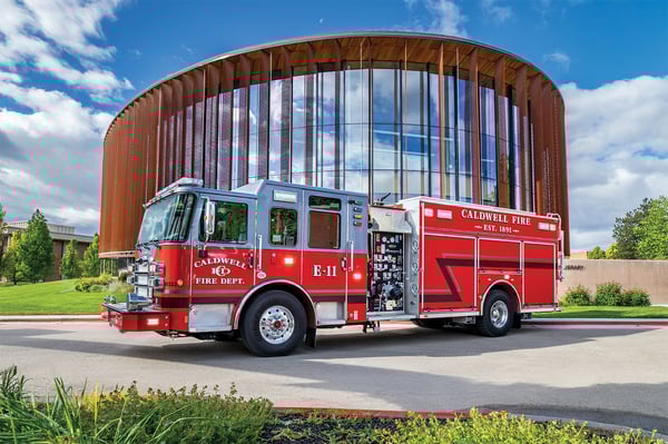 The drivers side of an Enforcer HDRP parked in front of a large building on a sunny day.
