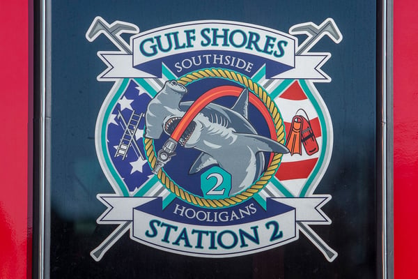 The logo of Gulf Shores Fire Department Station two on the crew cab window of a fire truck.