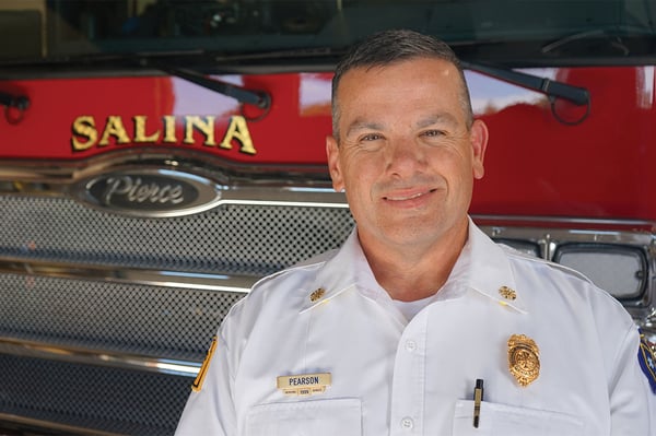 The fire chief of Salina Fire Department posed in front of a fire truck.