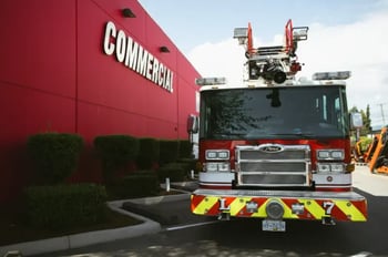 A Pierce fire truck parked in front of the red Commercial Emergency Equipment building.