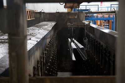 Firetruck frame rails undergo the e-coat process in a manufacturing facility.
