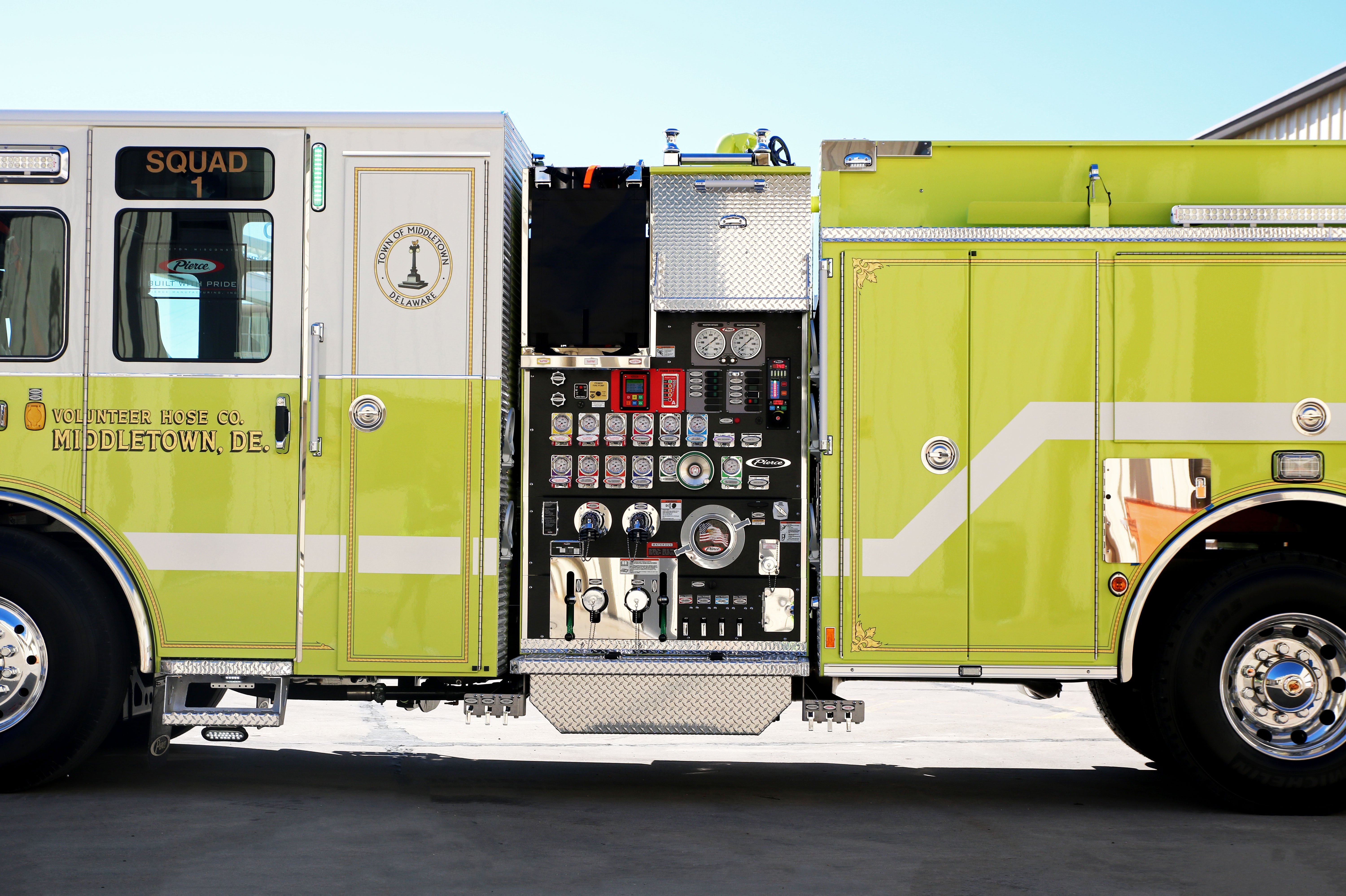 Side Mount Crosslays with T-handle valve controls on the driver’s side of a Pierce Fire Truck parked outside on a sunny day. 