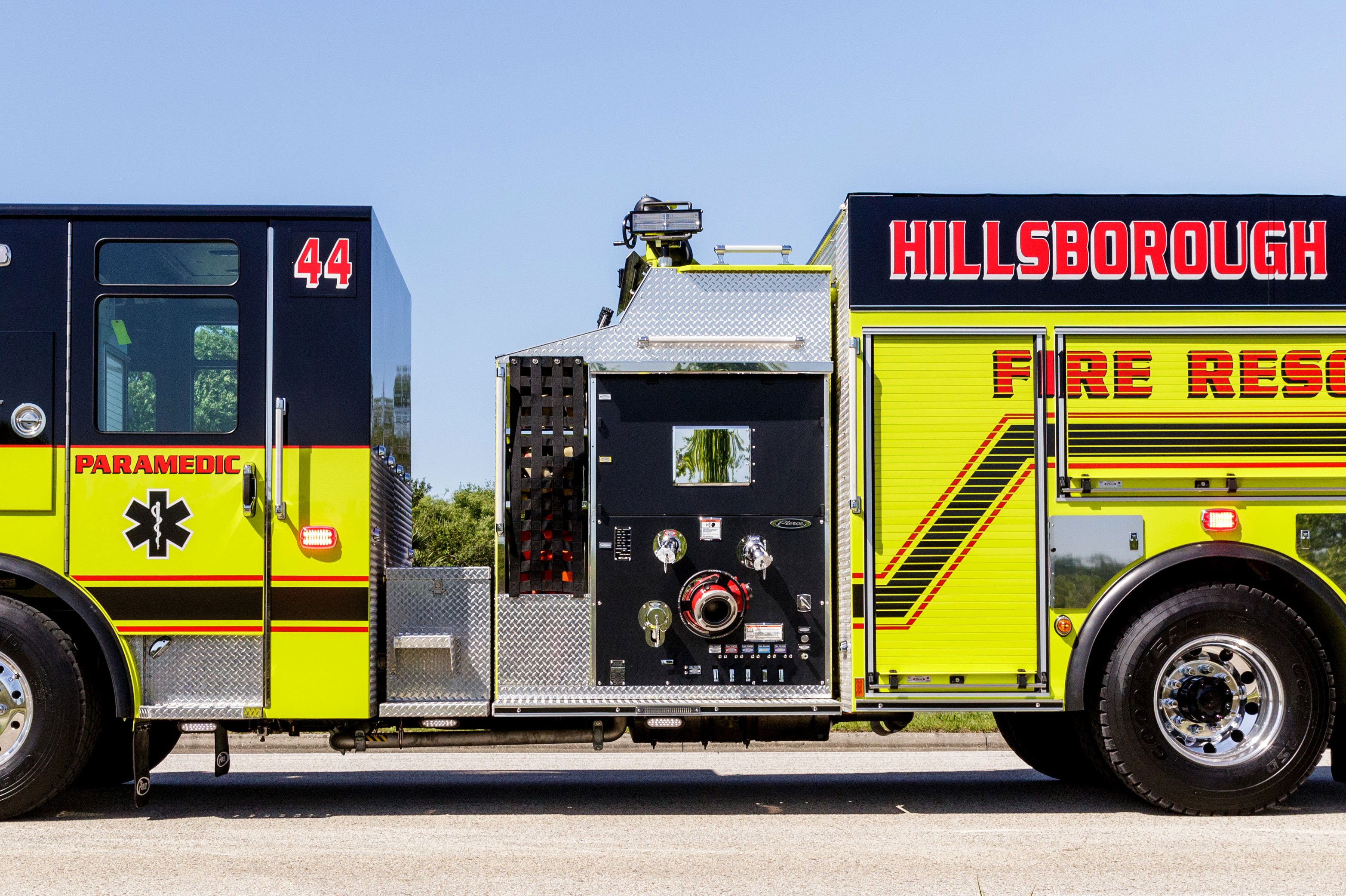 Top-Mount pump panel on a Pierce Fire Truck parked outside on a sunny day. 