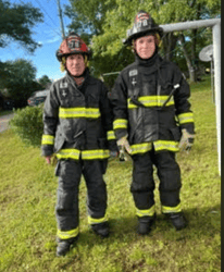 Captain Tom Janssen and his son, Oliver, stand together in full firefighter bunker gear.