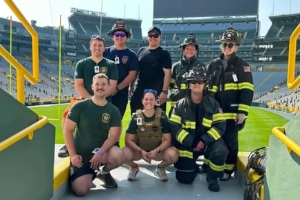 First responders and firefighters pose at Lambeau Field during the 9/11 Memorial Stair Climb event.