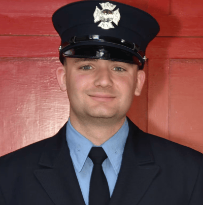 Official portrait of FDNY firefighter Paul Tegtmeier in a dress uniform and service cap.
