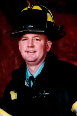 Portrait of FDNY firefighter Paul Tegtmeier in his firefighting helmet and turnout gear.