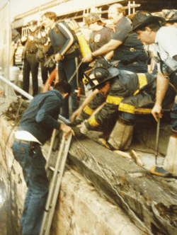 An old picture of a group of fire fighters making a rescue.