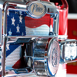 Close-up of a Pierce fire truck chrome grille with a United States flag insert.
