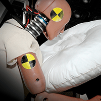 A crash-test dummy in a seat with a deployed airbag during Pierce fire truck safety testing.