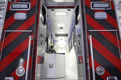 A rear shot of the Lexington County Fire Service rescue truck with the doors open showing the chrome interior flanked by red and black stiped exterior.