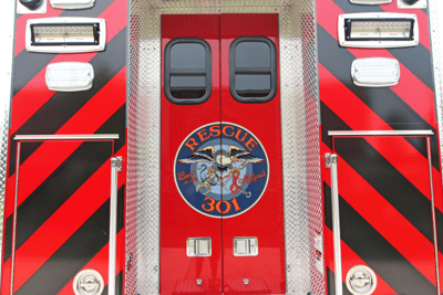 A rear shot of the Lexington County Fire Service rescue truck with red and black stripes and a blue circle logo with an eagle that reads ‘Rescue 301.’