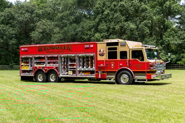 The officer's side of a Heavy-Duty Rescue fire truck with the compartments open showing tools and equipment inside.
