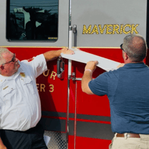 A red and gray fire truck with the word 'Maverick' being revealed.
