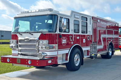 A red and white Pierce PUC Pumper with blue sky in the background.