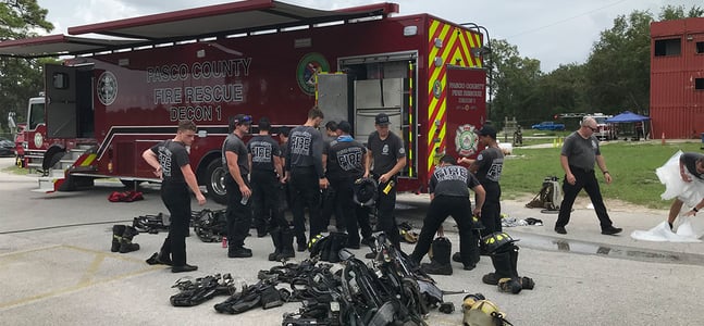 A group of firefighters and their gear outside of the Pasco County Decon 1 vehicle