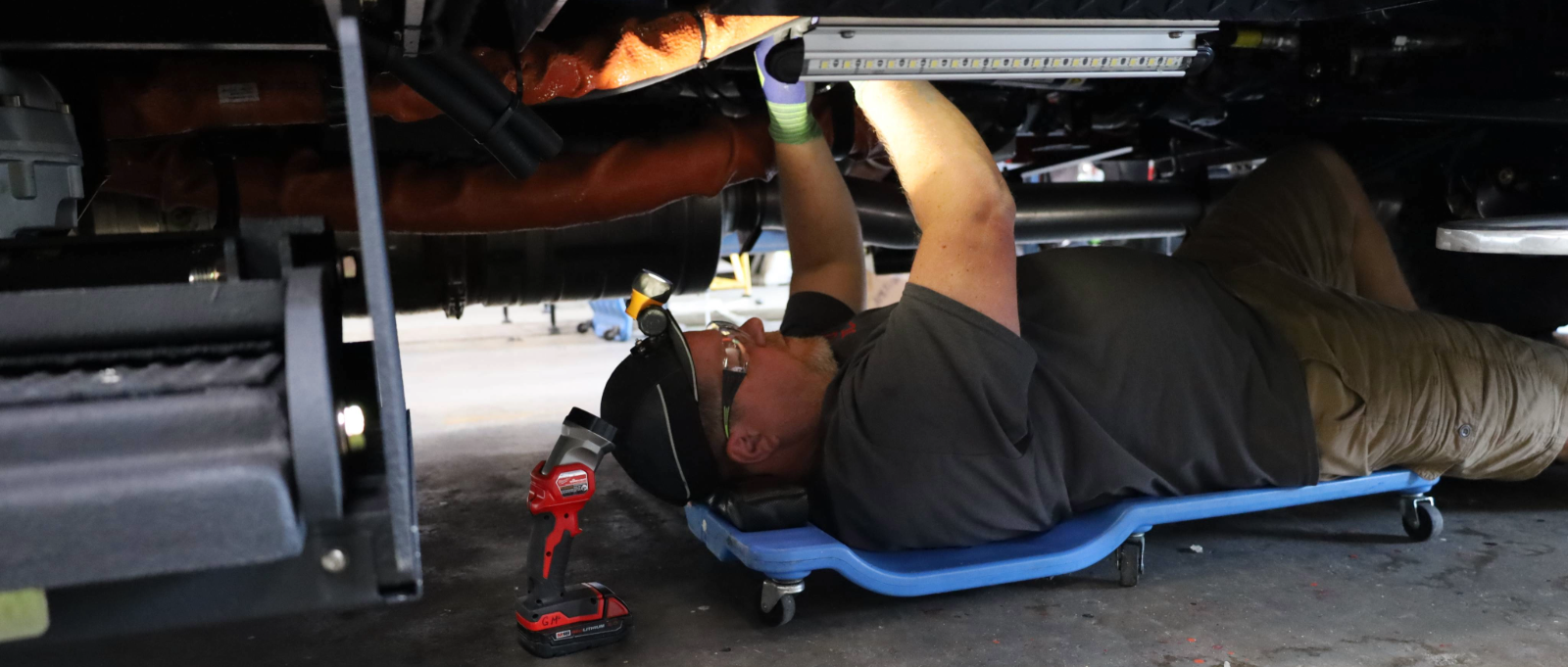 A technician working underneath a fire truck.