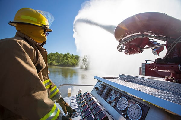 Pierce High Flow Industrial Pumper Fire Truck with a firefighter spraying foam from the Husky 450 Foam System. 
