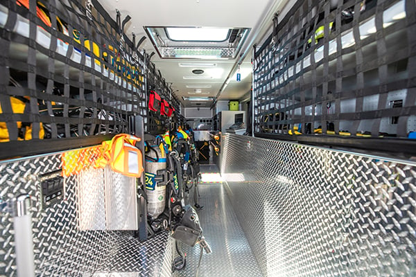 Interior of a Pierce Walk-In Heavy-duty Rescue Fire Truck with storage compartments on the left and right side and a walkway in the middle. 