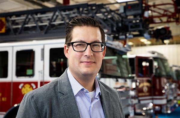 President of Pierce Manufacturing, Bob Schulz, standing near a Pierce custom firetruck.