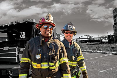 Firefighters next to a Pierce fire truck with Milwaukee's Hoan Bridge in the background