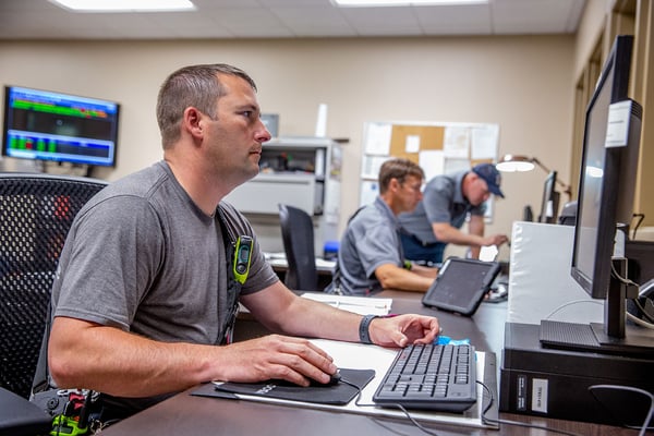 A firefighter working on a computer at a fire station.