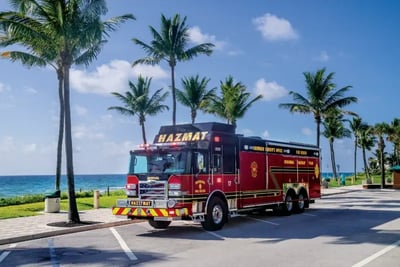 Broward County Fire Rescue regional HAZMAT truck on a palm tree-lined road near the beach.