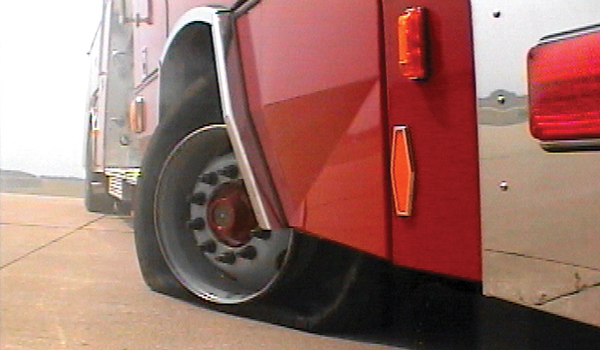 Pierce Fire Truck parked outside in a parking lot with a flat tire. 