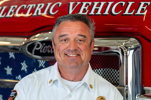 The fire chief of the Gilbert Fire and Rescue in front of an electric fire truck.