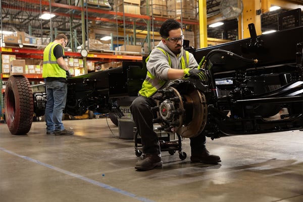 A manufacturing employee building the Pierce Tak4 T3 Rear Suspension for a fire truck