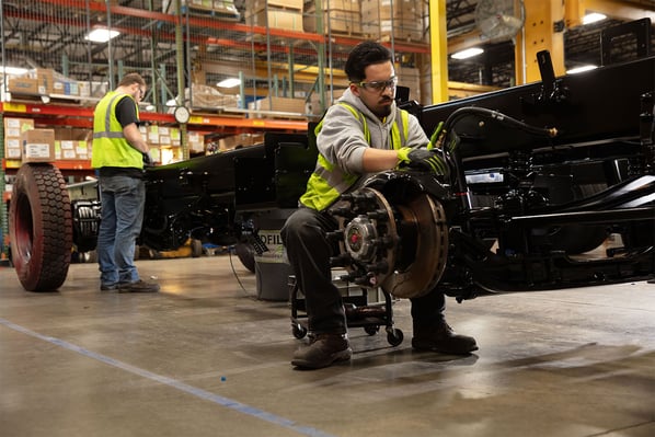 A manufacturing employee building the Pierce Tak4 T3 Rear Suspension for a fire truck