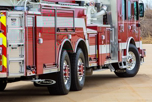 The rear officer's side of a Pierce Ascendant 100 Aerial Tower with Tak4 T3 Rear Suspension.
