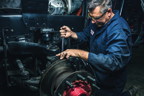 A certified technician servicing the TAK-4® Suspension System on a Pierce Fire Truck. 