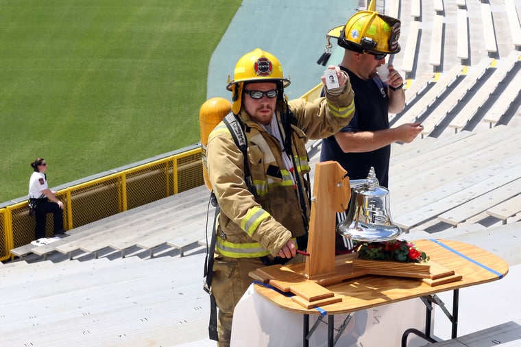 A firefighter ringing the bell at the Pierce Manufacturing 9/11 Stair Climb event at Lambeau Field. 