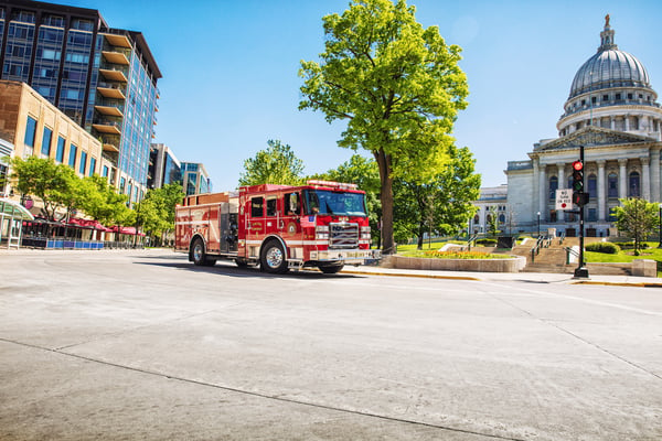 Pierce Volterra electric fire truck parked outside by a tree at the Wisconsin State Capital in Madison on a sunny day. 