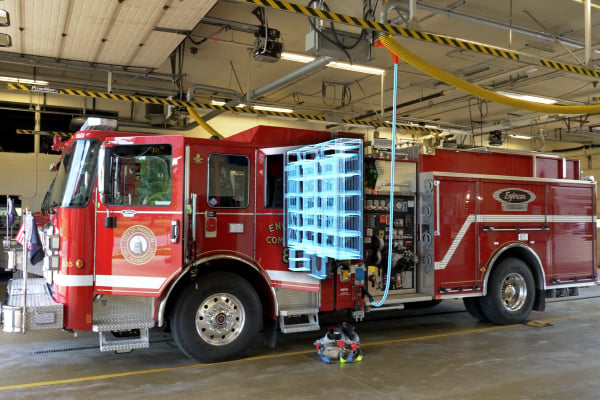 Pierce Volterra electric fire truck parked in a fire station charging the internal battery system. 