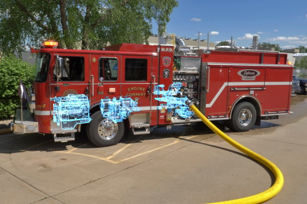 Pierce Volterra electric fire truck parked on the road pumping water through a hose. 